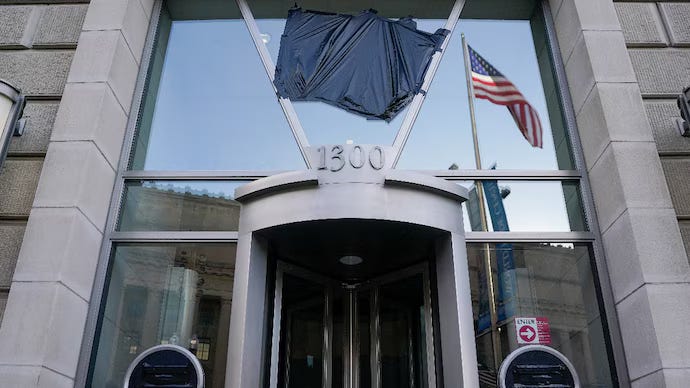 Photo of the entrance of the Ronald Reagan Building in Washington, DC with black plastic covering the USAID logo.