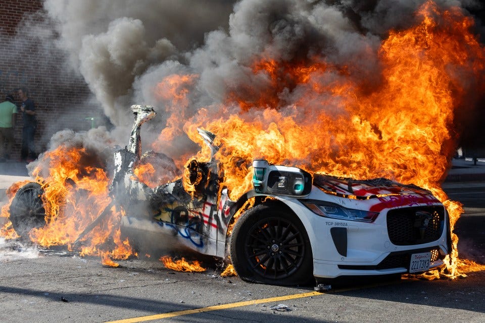 A burning Waymo vehicle during a protest in Los Angeles.
