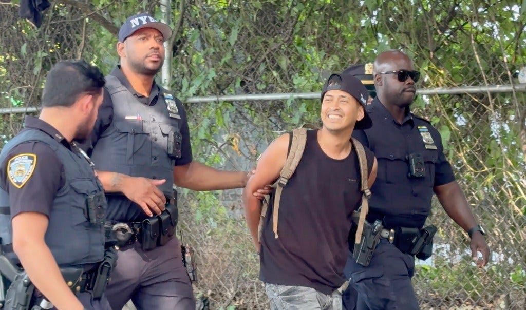 An unidentified man is arrested while the illegal migrant encampment and market on Randalls Island