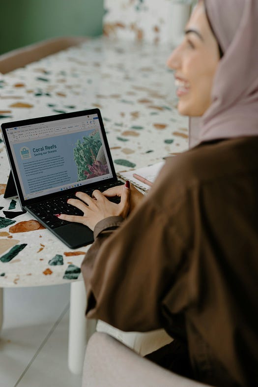 Young woman typing on a laptop.