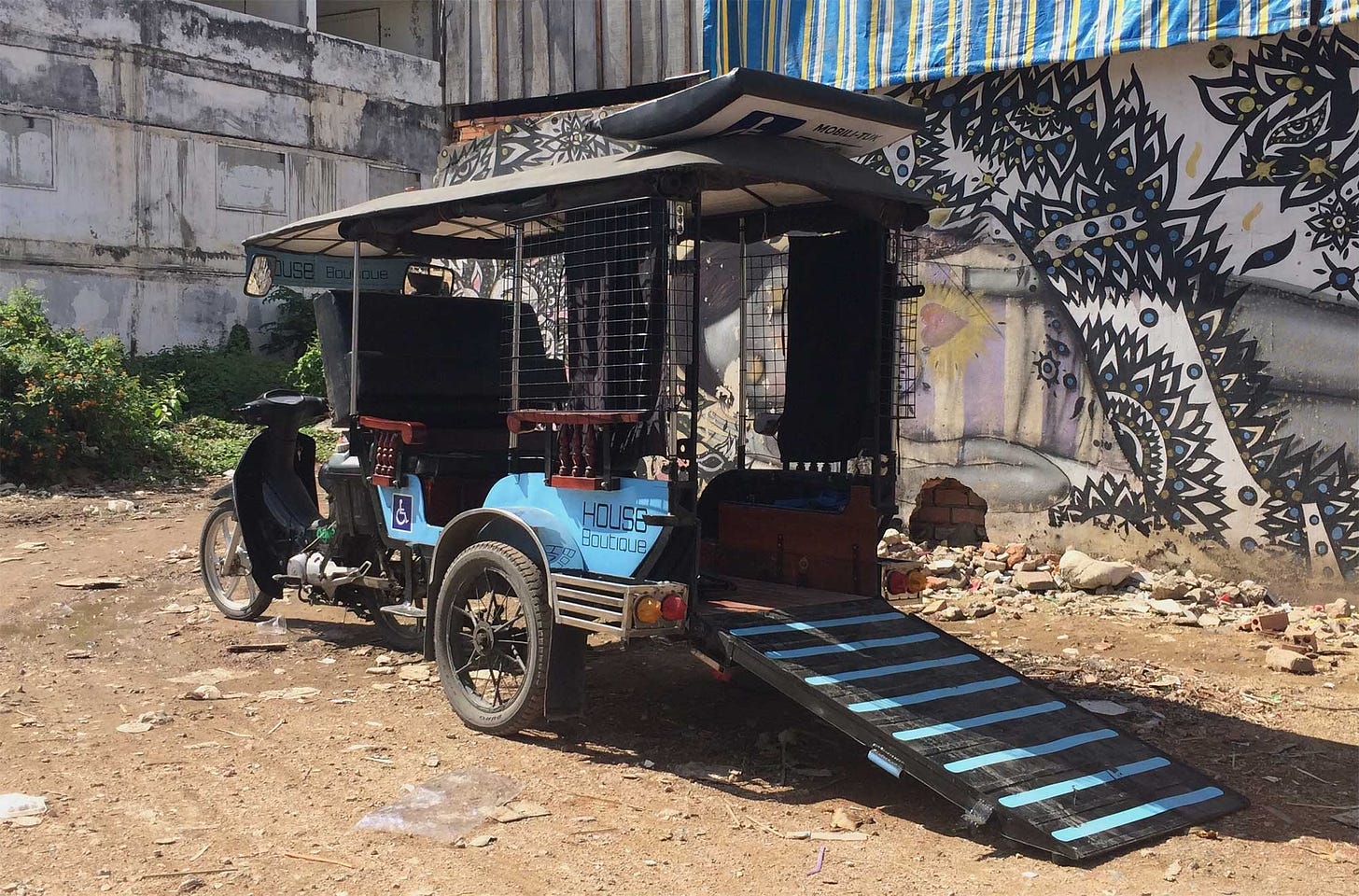 Tuk-tuk with wheelchair accessible ramp at the back of the carriage.