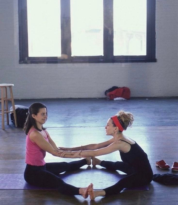This may contain: two women sitting on the floor with their hands together