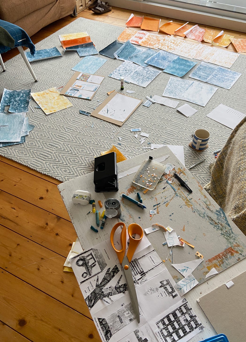 Living room floor covered with cut up colourful collage paper. Nanette Regan