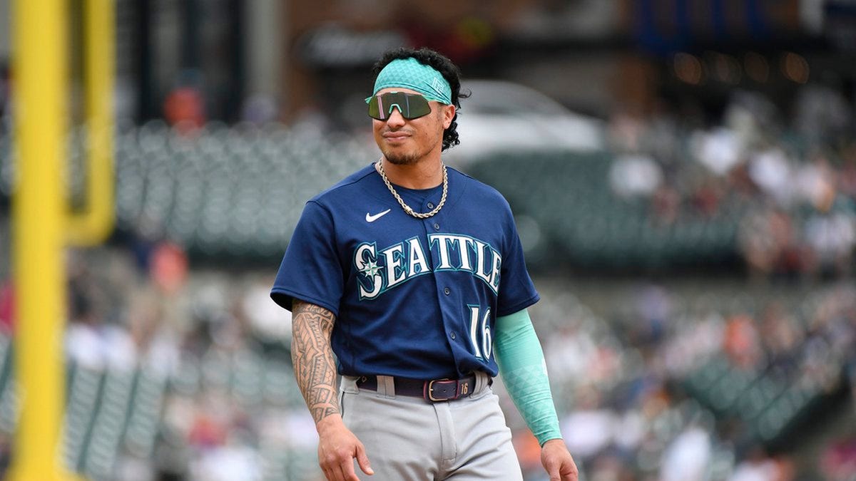 Seattle Mariners' Kolten Wong looks at the dugout at the end of the ninth inning of a baseball...