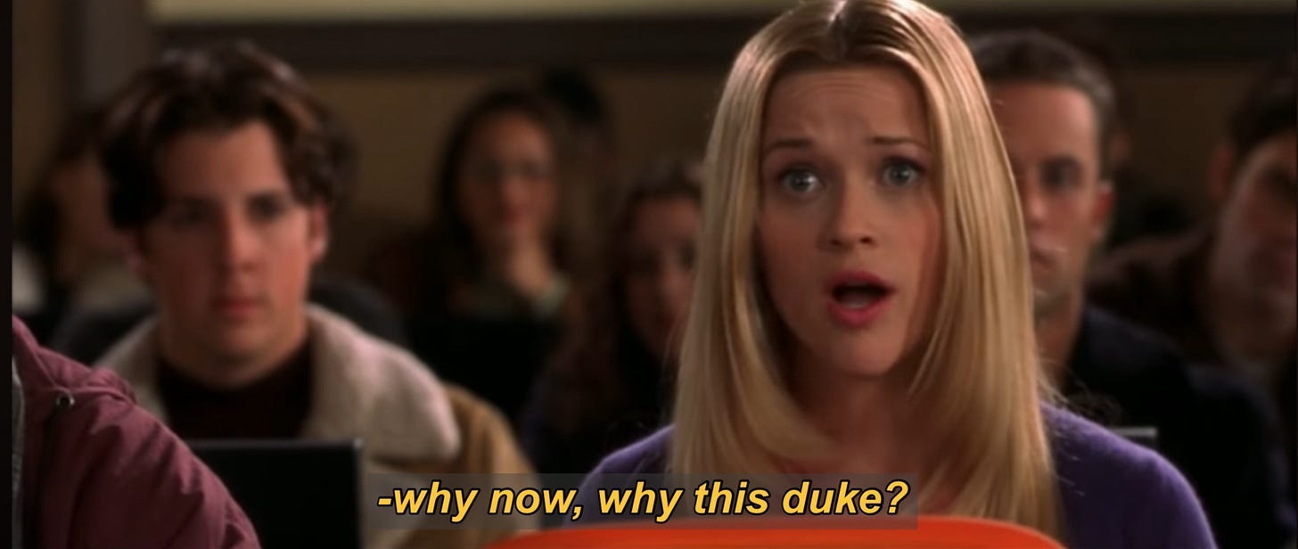 Blonde woman sitting in a lecture hall, with the caption, "why now why this duke?"