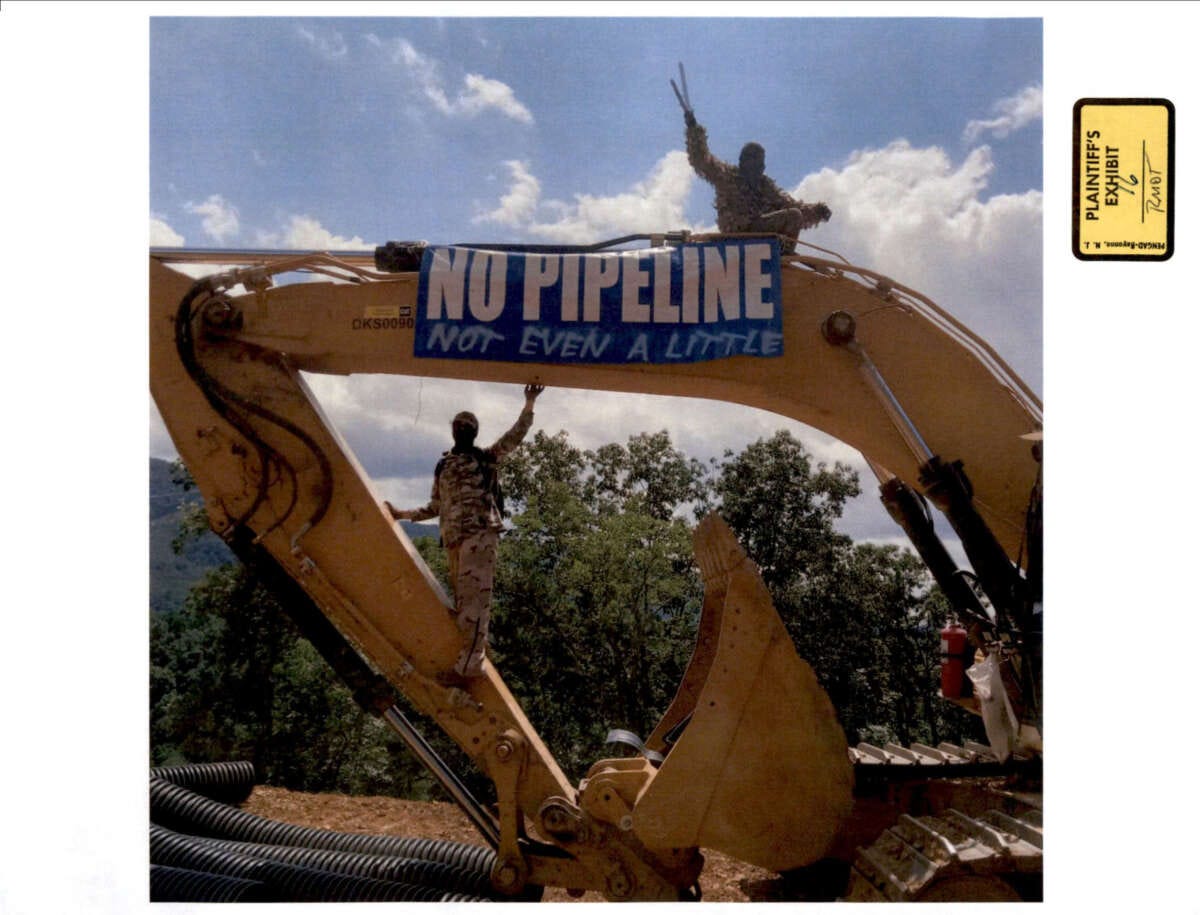 Appalachians Against Pipelines protesters erect a banner on construction equipment during a 2023 protest. Mountain Valley Pipeline submitted the photo as an exhibit in a civil suit seeking injunctions against protesters.