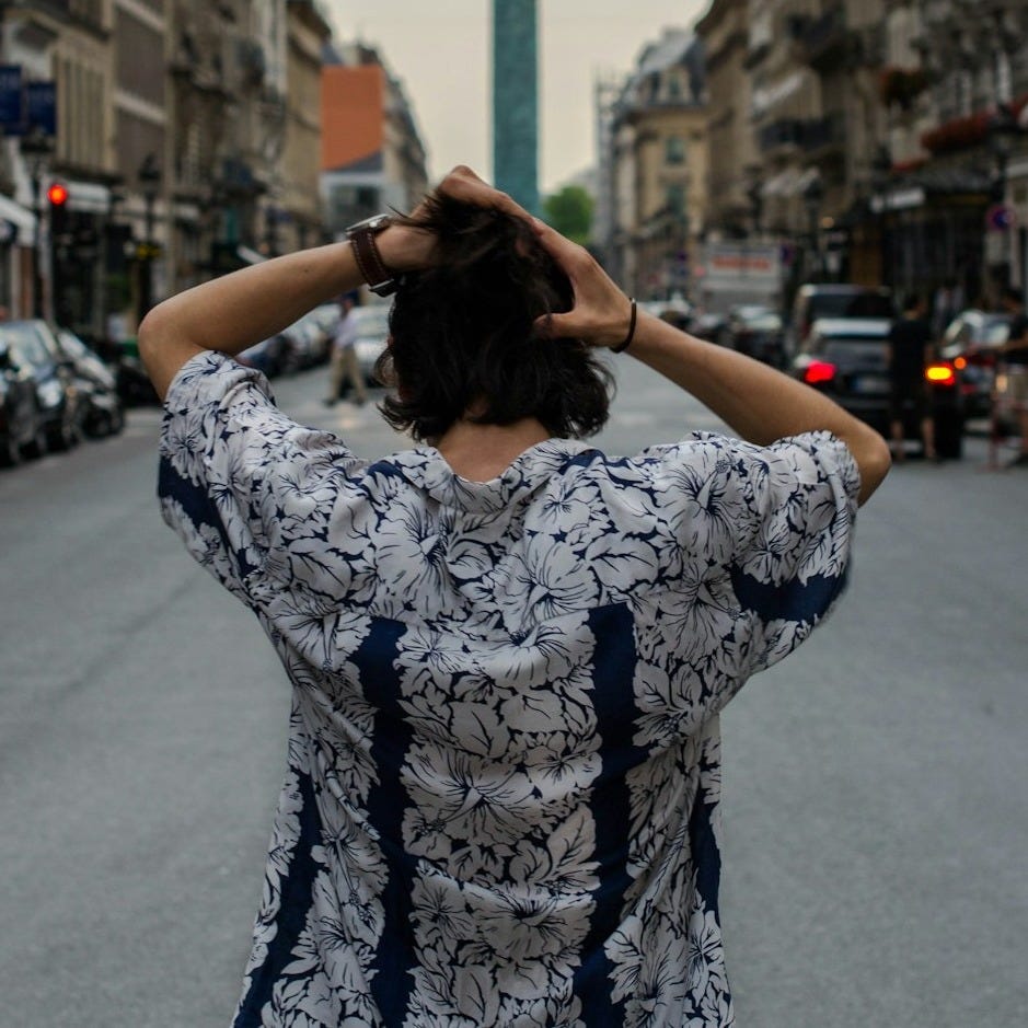 back view of man wearing floral top while fixing his hair