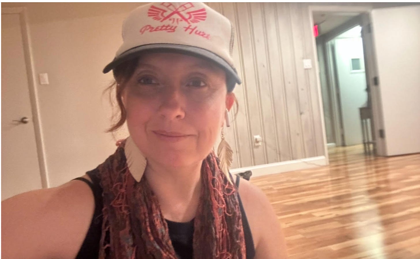 Julie Johnson selfie with a hat on inside a yoga studio