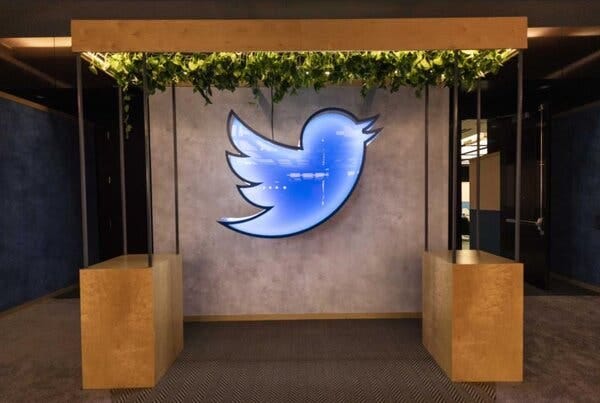 A large blue neon light display in the shape of Twitter’s bird logo.