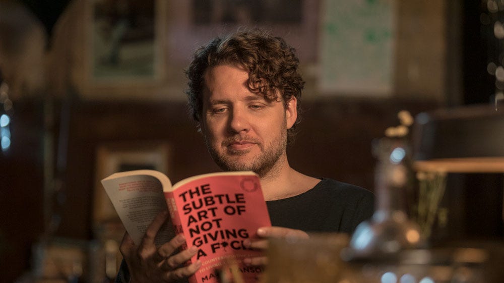 A man reading the Subtle Art of Not Giving a Fuck in the trailer for the film of the same name!