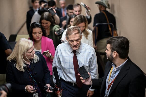 Rep. Jim Jordan surrounded by journalists in a hallway at the Capitol.
