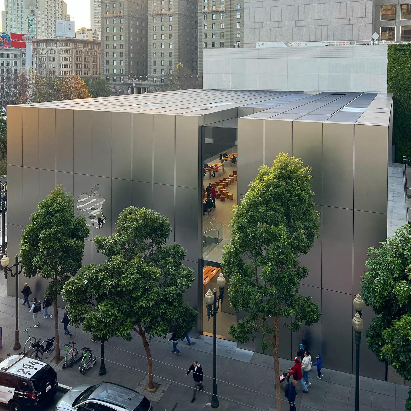 Apple Union Square, shot from an upper floor in a building across the street. The store interior is visible through narrow windows on the side of the building.
