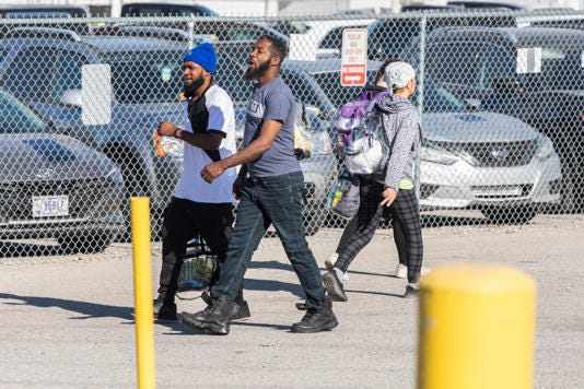 Tyson Foods employees come and go between shifts at the Tyson Food Processing Plant that is located in Indiana. Tyson has been accused of allegedly replacing citizen employees with migrant employees in an effort to decrease pay. LP Media