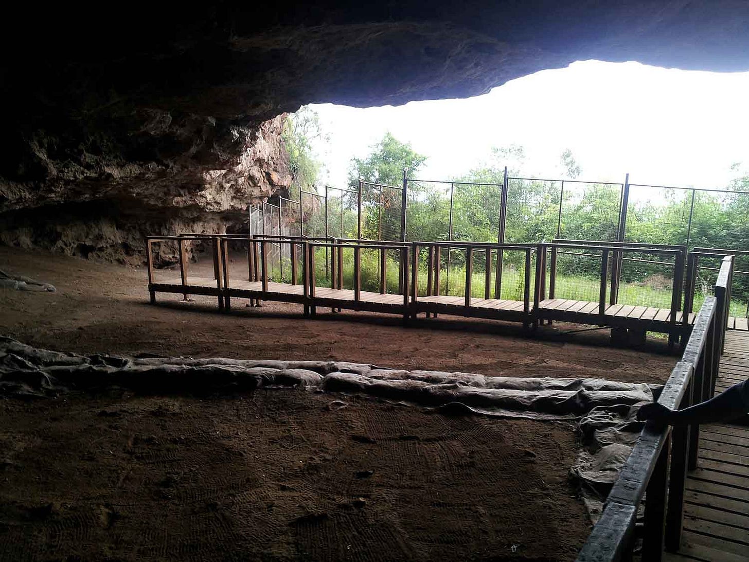 View from inside a cave looking at railing and sandbags View from inside a cave looking at railing and sandbags