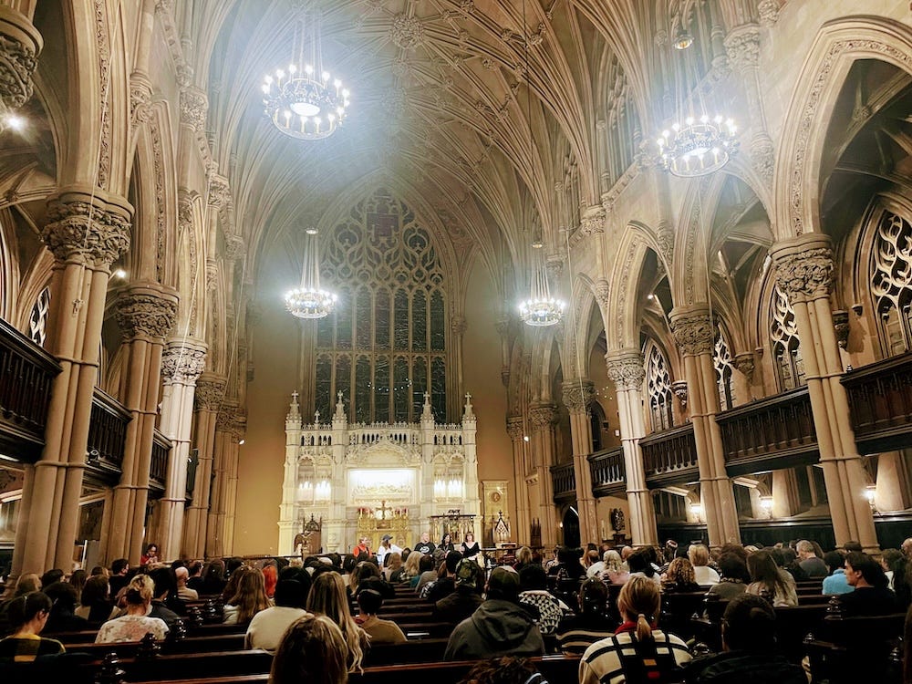 A church with vaulted ceilings and stained glass windows and brilliantly lit chandeliers, packed for Jami Attenberg's book launch