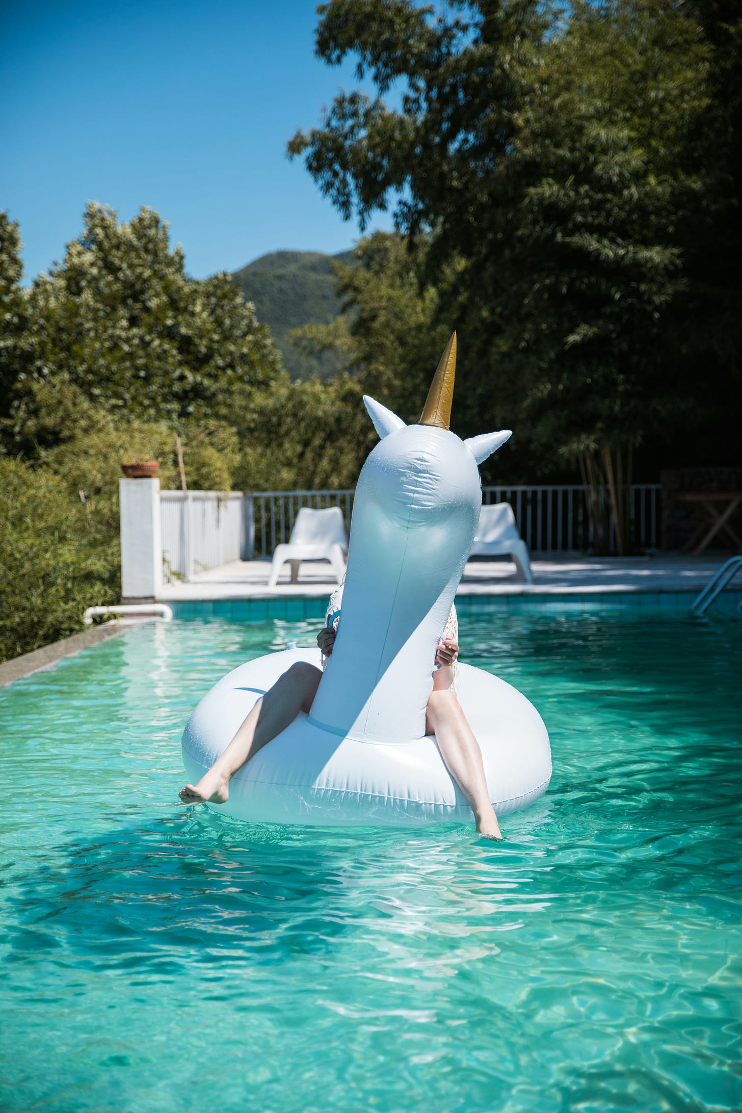 Woman on floating unicorn in a pool
