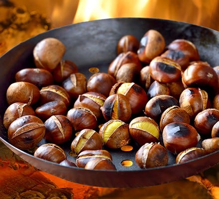 Roasting chestnuts in a pan over open fire