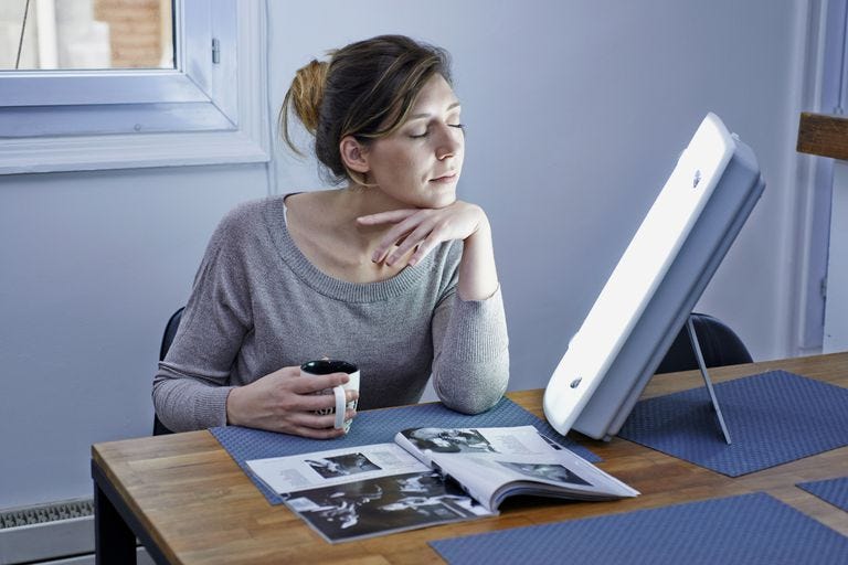 woman using lightbox to fight sad seasonal affective disorder