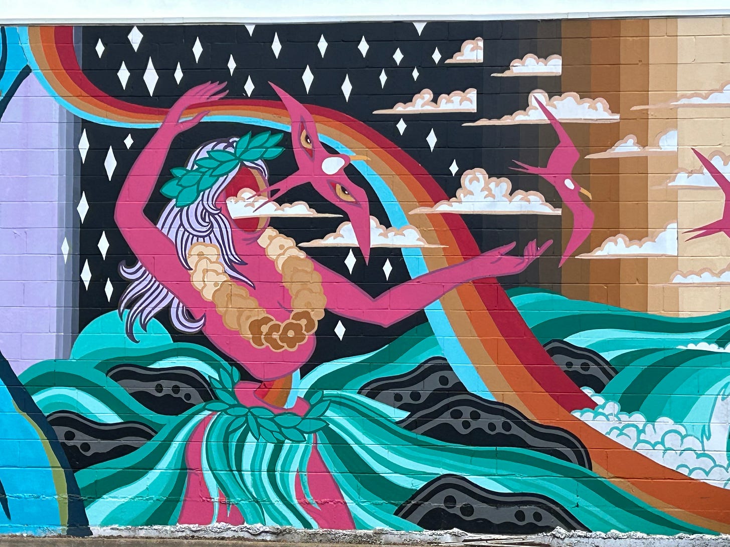 Mural art from Kauai of a hula dancer with her eyes flying off her face on the body of a pink bird.