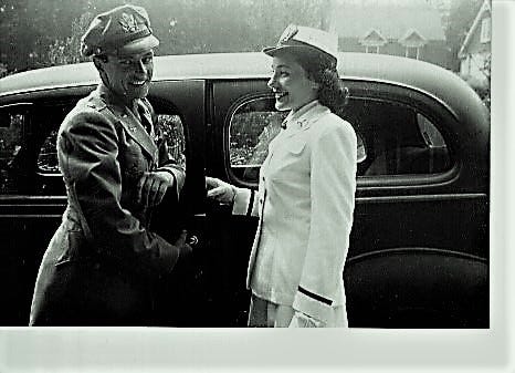Man and women both in uniform stand outside of a car