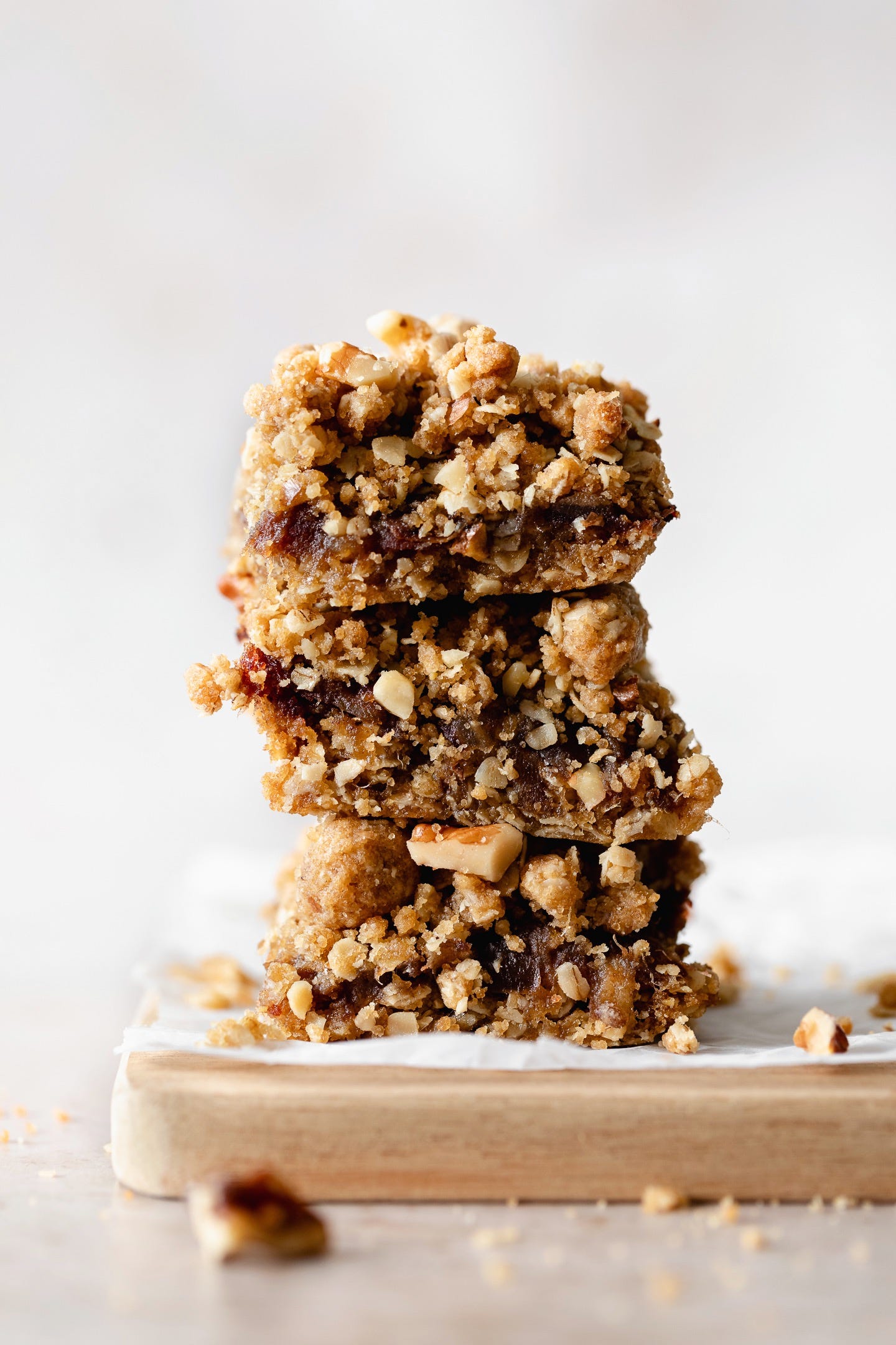 Vegan date walnut bars stacked up on a white background