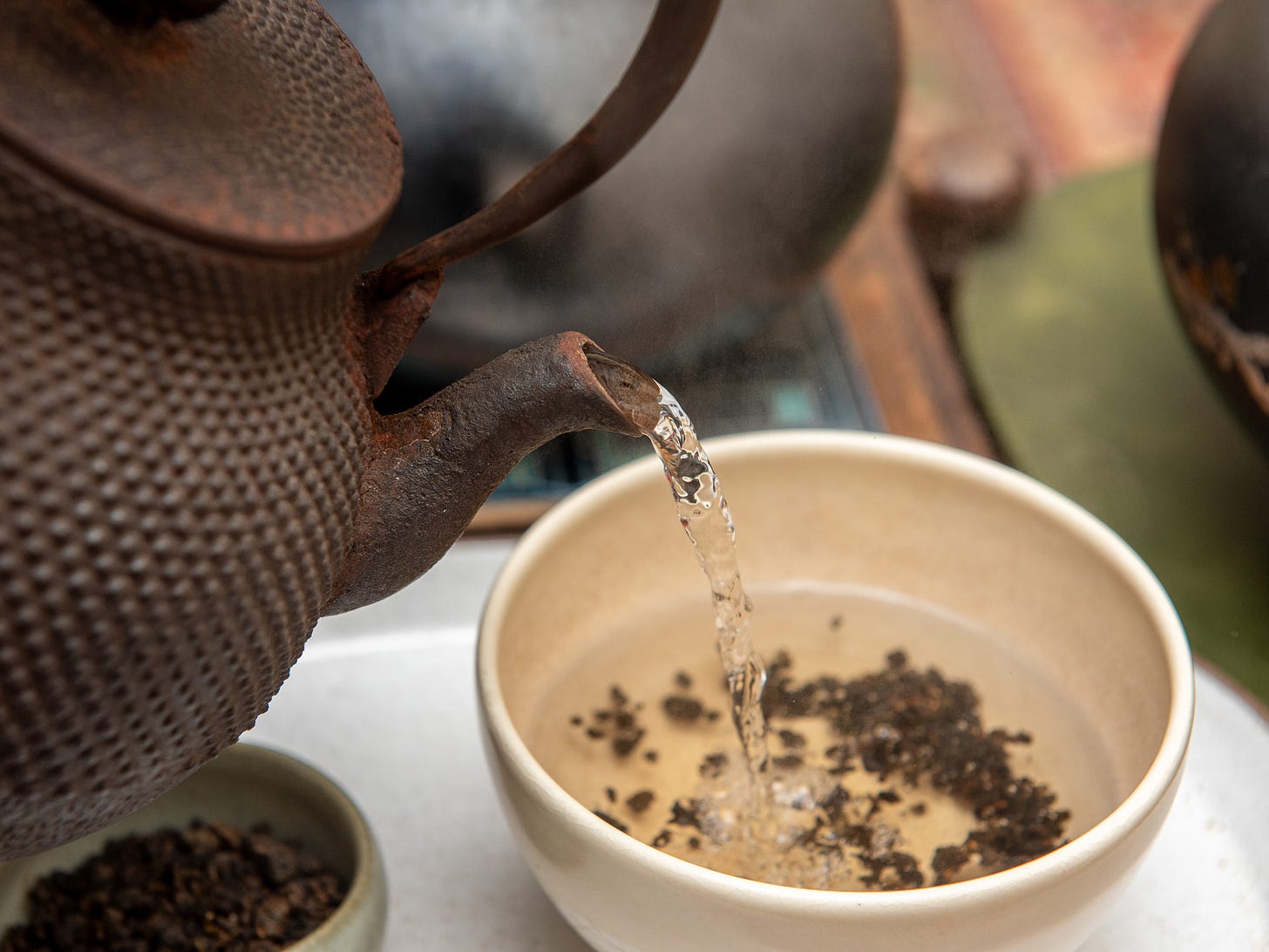 ID: Pouring water into tea bowl from an iron tetsubin kettle