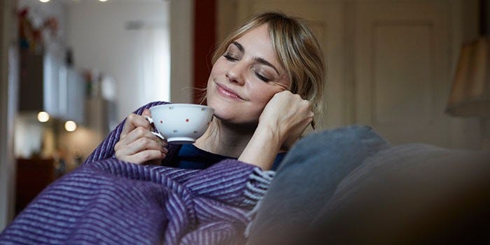 A woman drinking tea feeling relaxed