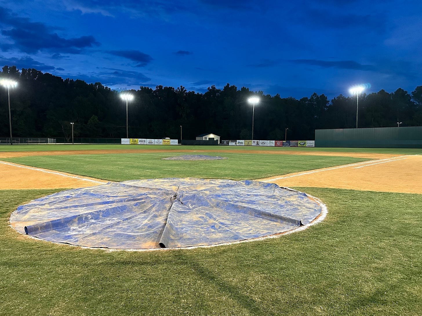 May be an image of softball, batting, scoreboard, grass, park and text