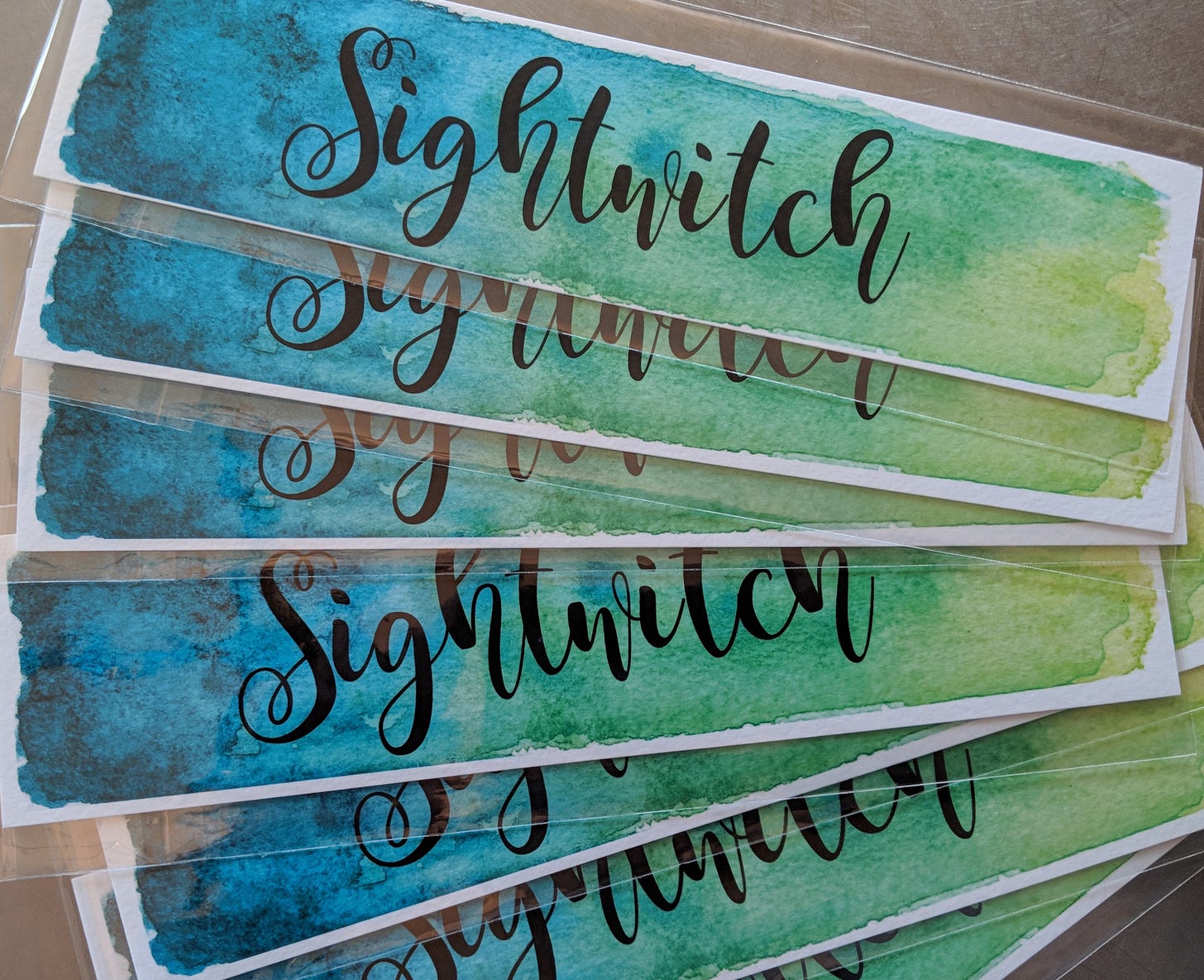 Bookmarks that say Sightwitch on them in watercolors