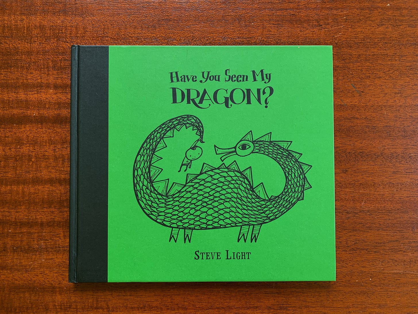 The front cover of "Have You Seen My Dragon?" by Steve Light. The cover is green and has an illustration of a dragon and a little boy holding its tail.