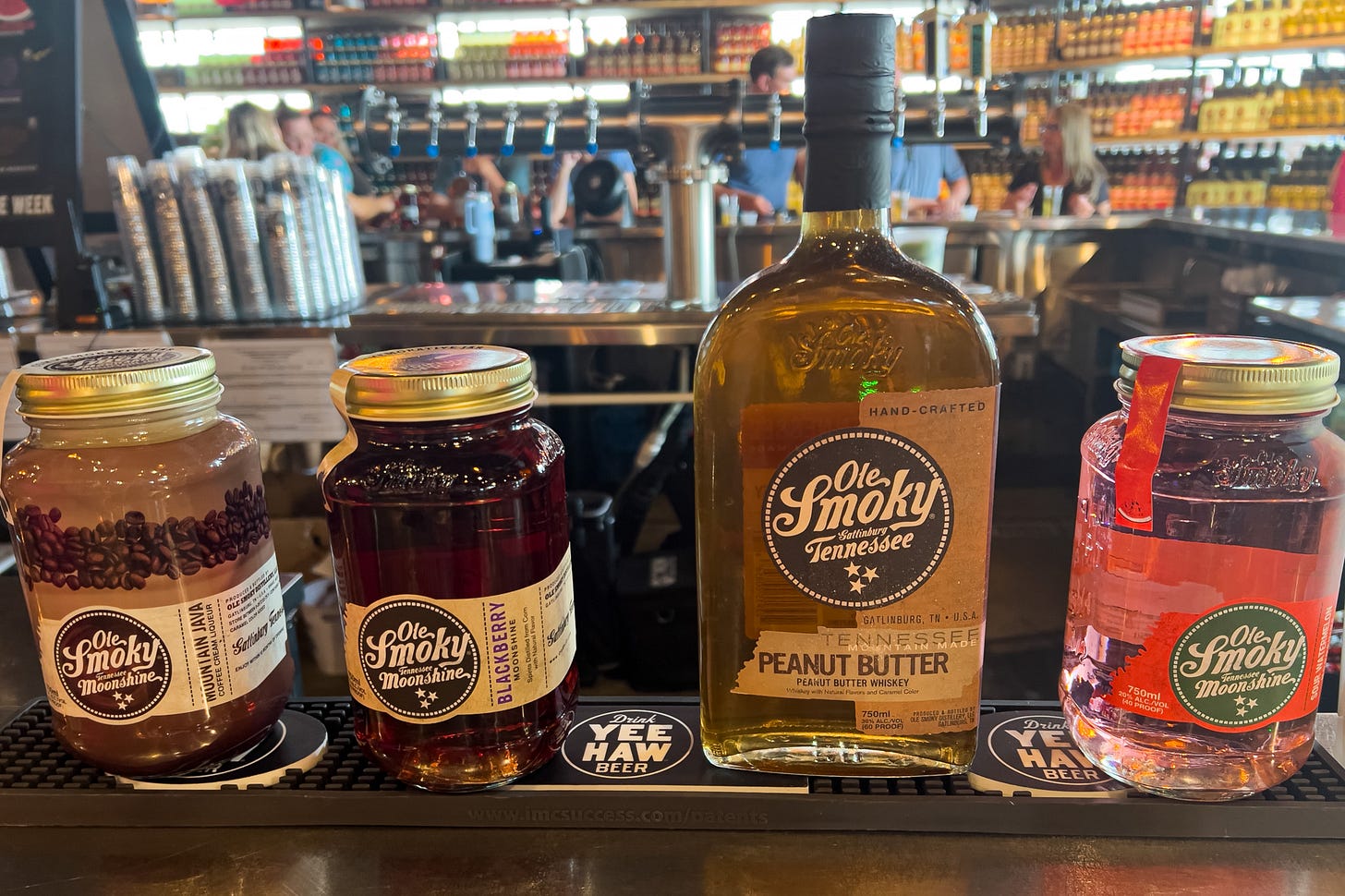 A line of Old Smokey moonshine jars: Mountain Java Coffee Cream Liqueur, Blackberry Moonshine, Tennessee Peanut Butter Whiskey, and Watermelon Moonshine 