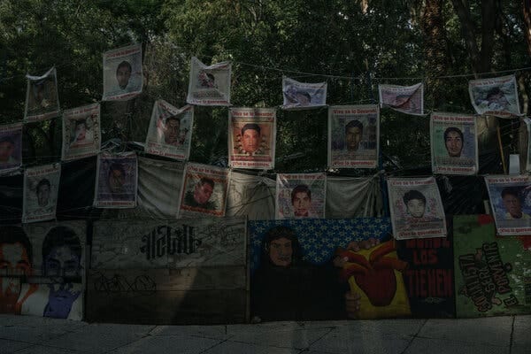 Missing persons posters with individual photos of the disappeared hang outside.