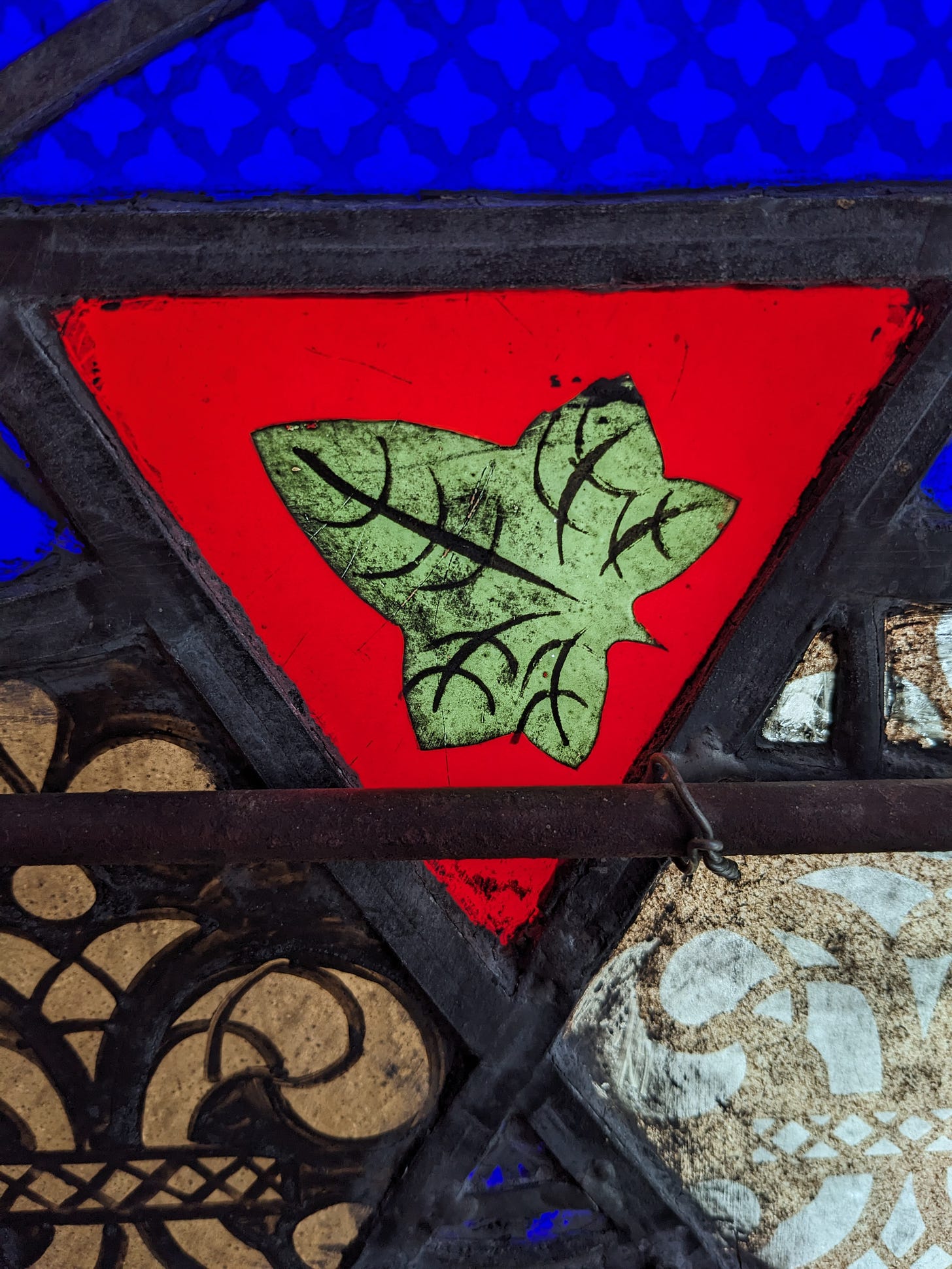 A collage of stained glass textures with a leaf in the center
