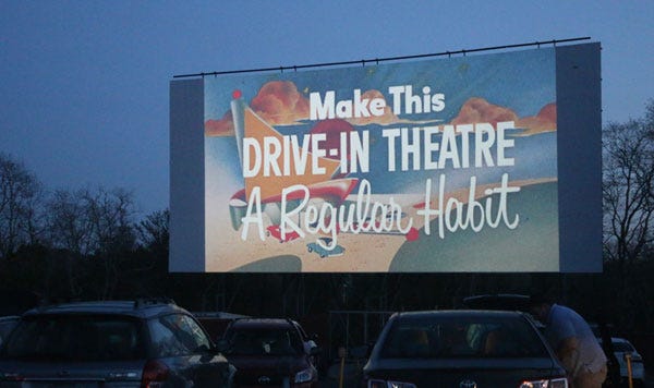 A Drive-In screen with the phrase "Make This Drive-In Theatre A Regular Habit" on screen