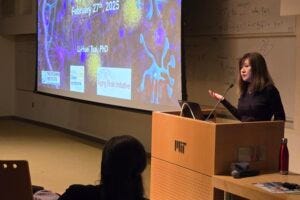 Li-Huei Tsai speaks about the latest gamma rhythm sensory stimulation research in her lab at an MIT colloquium Feb. 27, 2025.