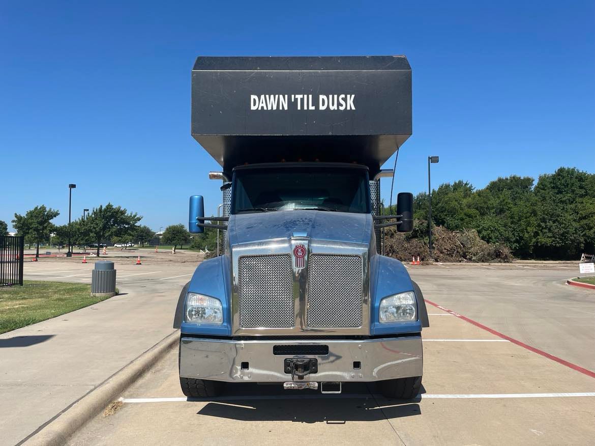 A large truck branded with the phrase "DAWN 'TIL DUSK"