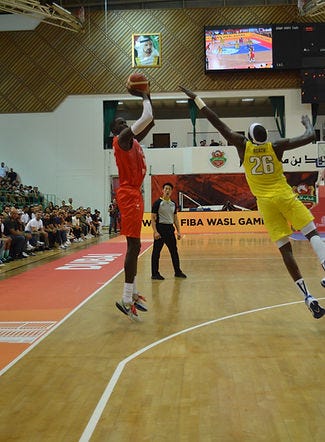 Thon maker, a professional basketball player, shooting a three while being defended by Duop Reath