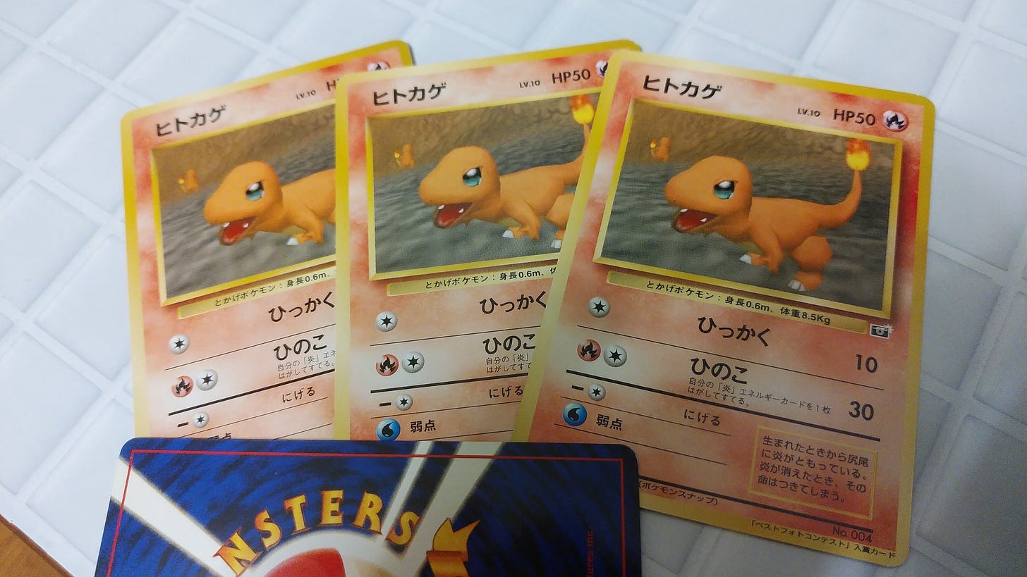 A photograph showing four of Tsukasa's Charmander cards, with one of them facing down. Only fifteen were ever printed!