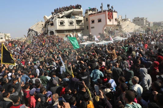 A crowd gathered Thursday outside the Gaza home of a slain Hamas leader to watch the release of hostages.