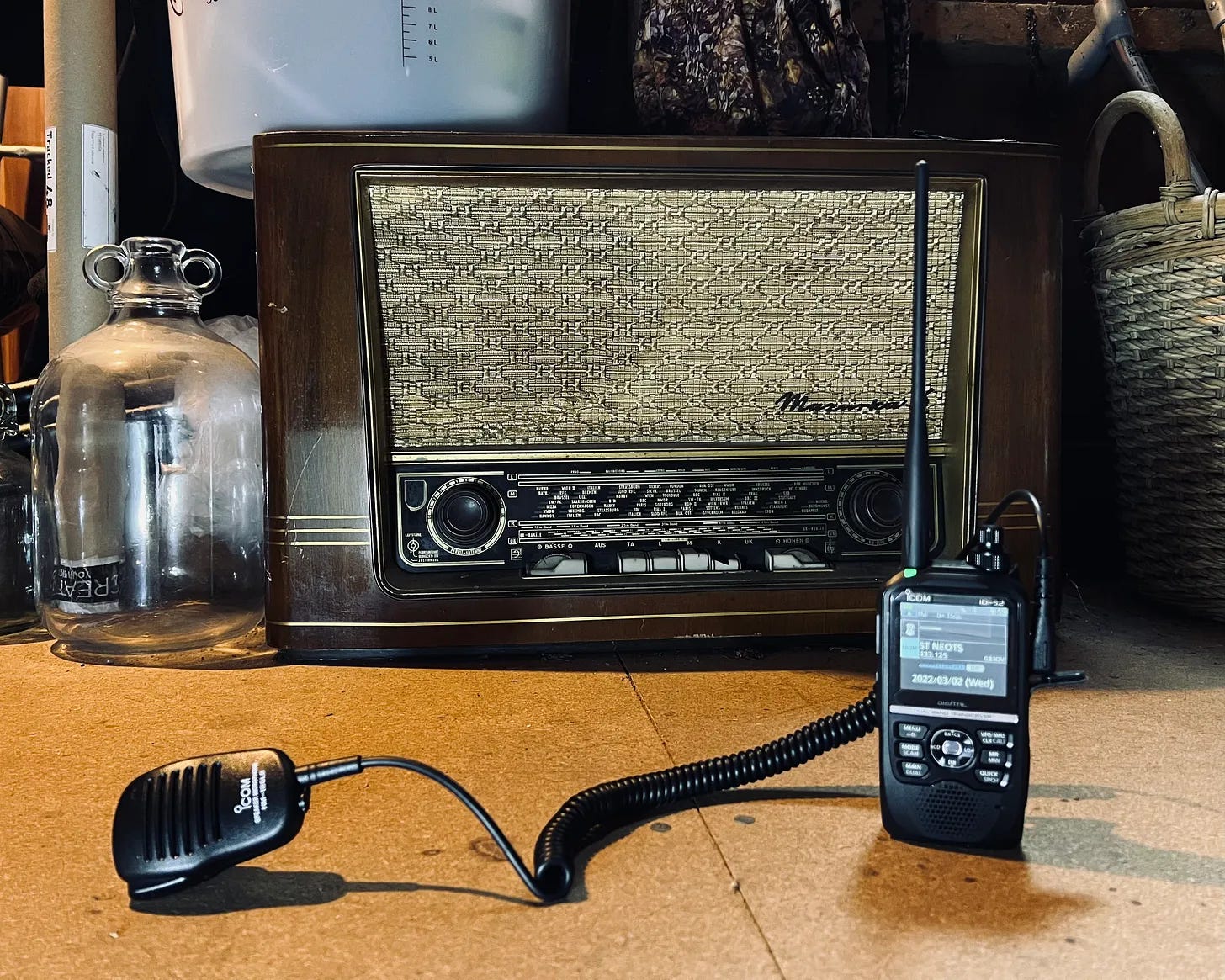 Two radios in an attic. A large valve radio and a state of the art handheld amateur radio