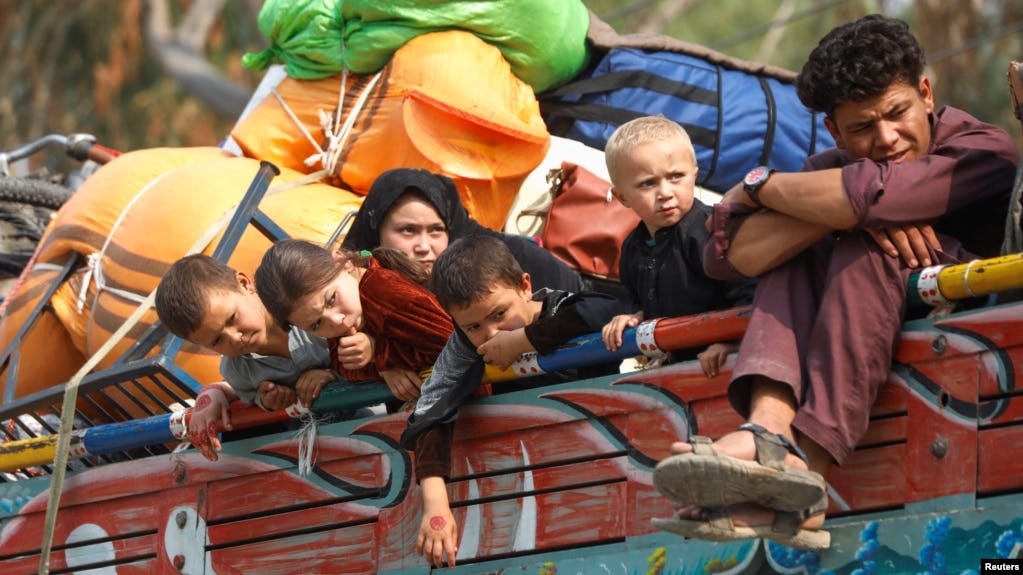 Afghan refugee children sit on a truck loaded with belongings as they and their families prepare to return home, outside the United Nations High Commissioner for Refugees repatriation centers in Azakhel town in Nowshera, Pakistan, Oct. 30, 2023.