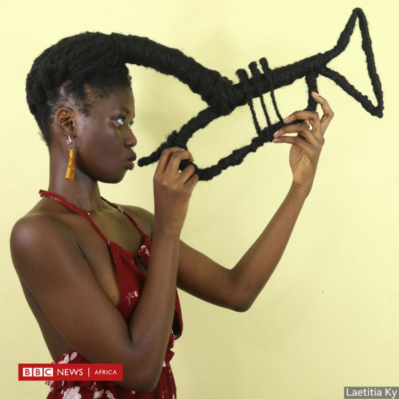 An African woman with her hair done in a complex hairstyle which looks like a trumpet