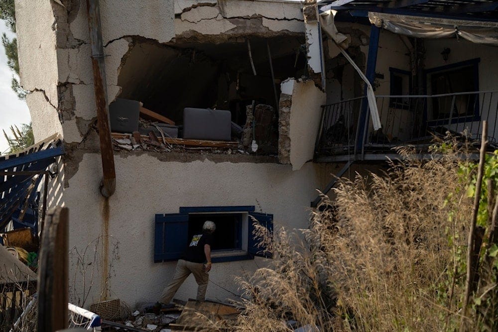 A settler checks a damaged house that was hit by a rocket fired from Lebanon, in the Kibbutz Manara, northern occupied Palestine, Thursday, Nov. 28, 2024. (AP Photo/Leo Correa)