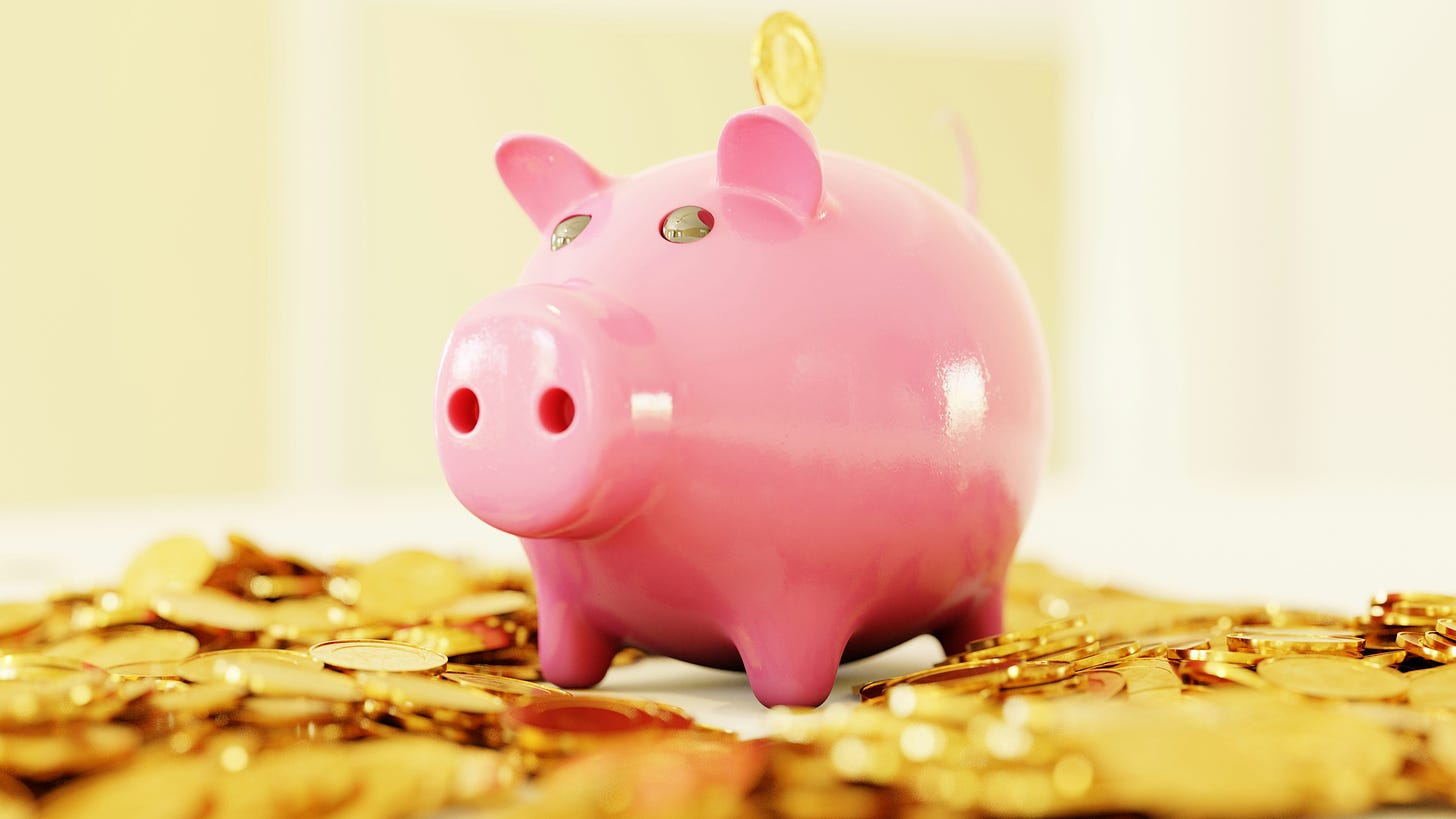 piggy bank sitting on pile of gold coins