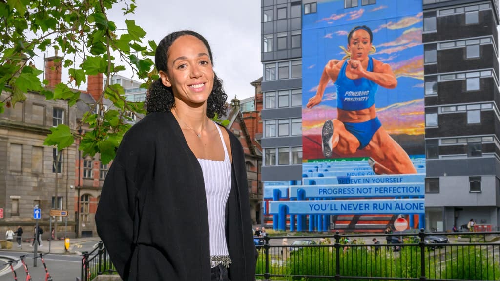 Katarina Johnson-Thompson standing in front of the 30 metre mural of her commissioned by British Gas