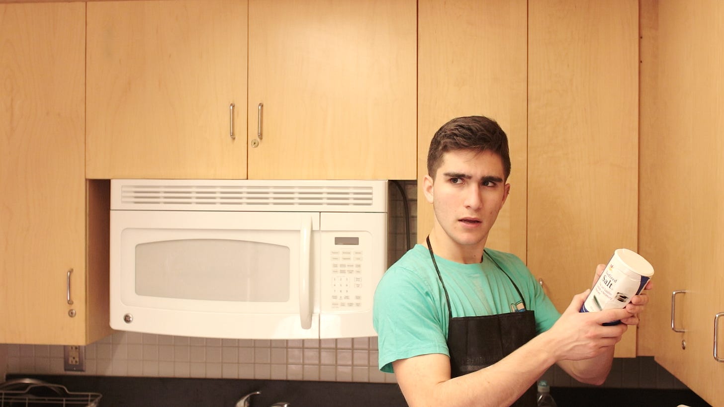 Fred Vincy (Oliver Shoulson) looks up mysteriously, while standing in a kitchen, wearing an apron and holding a tub of salt. Fred Vincy (Oliver Shoulson) looks up mysteriously, while standing in a kitchen, wearing an apron and holding a tub of salt.