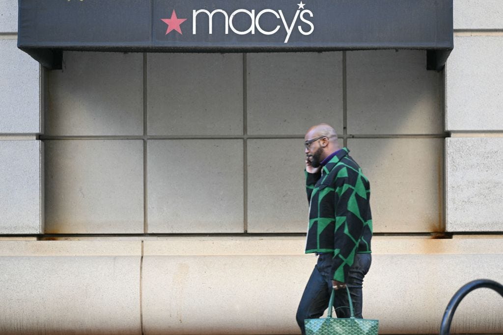 A man walks past a Macy's store.