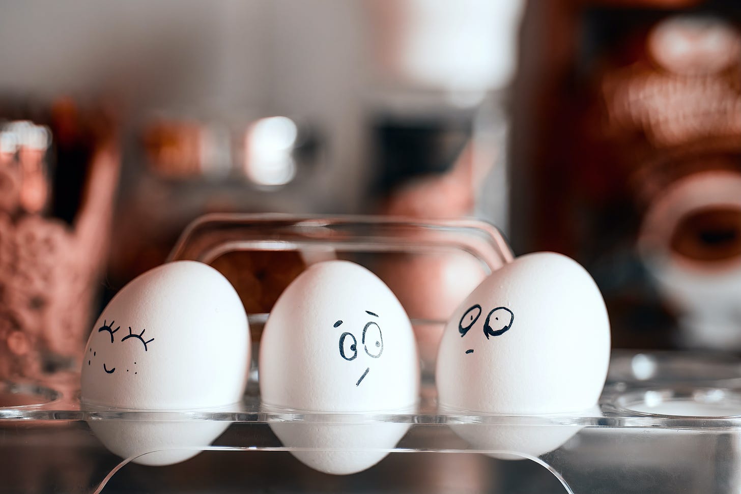 three white eggs with faces on them and blurred background 