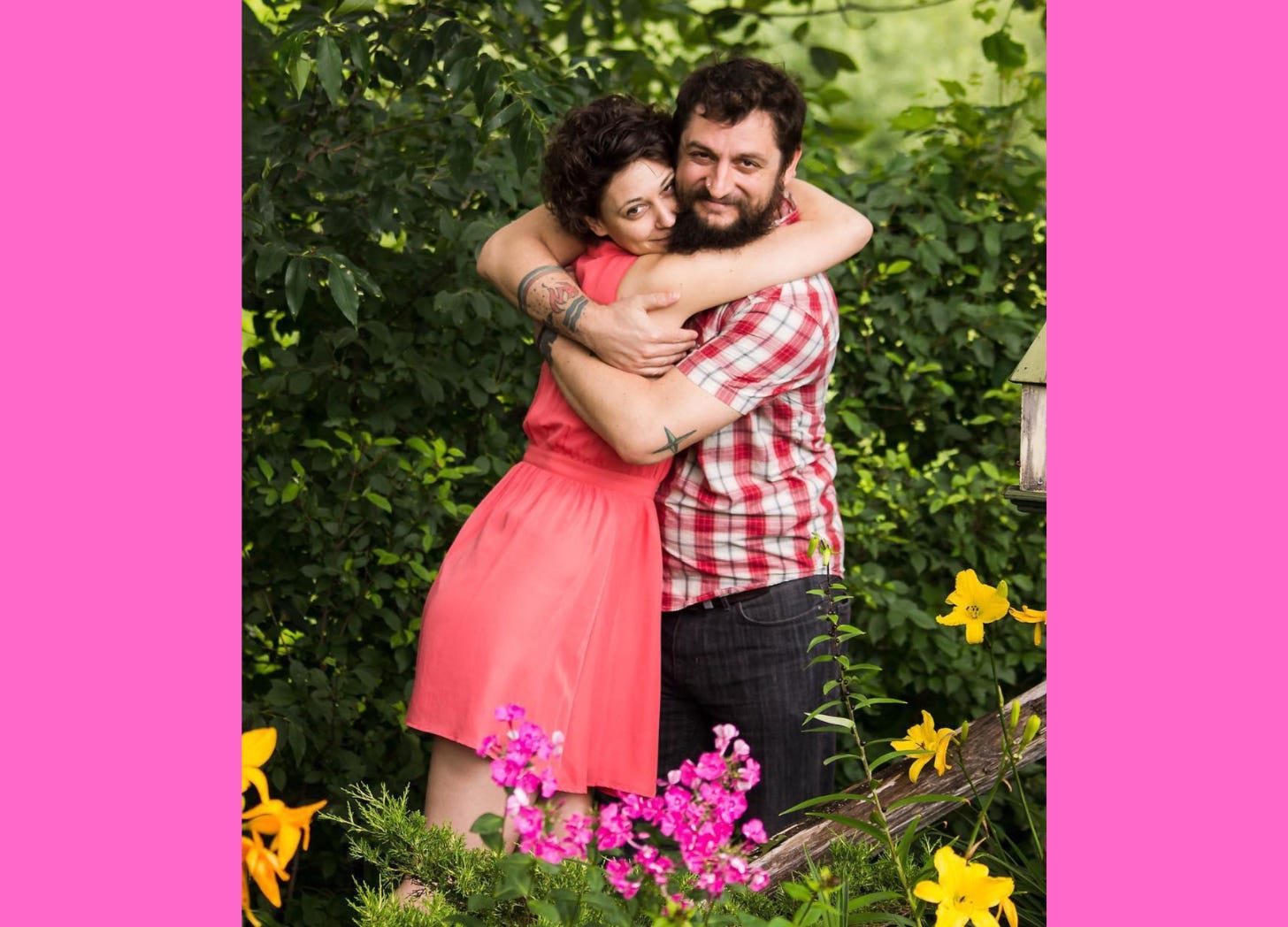 Couple hugging in a garden with flowers.