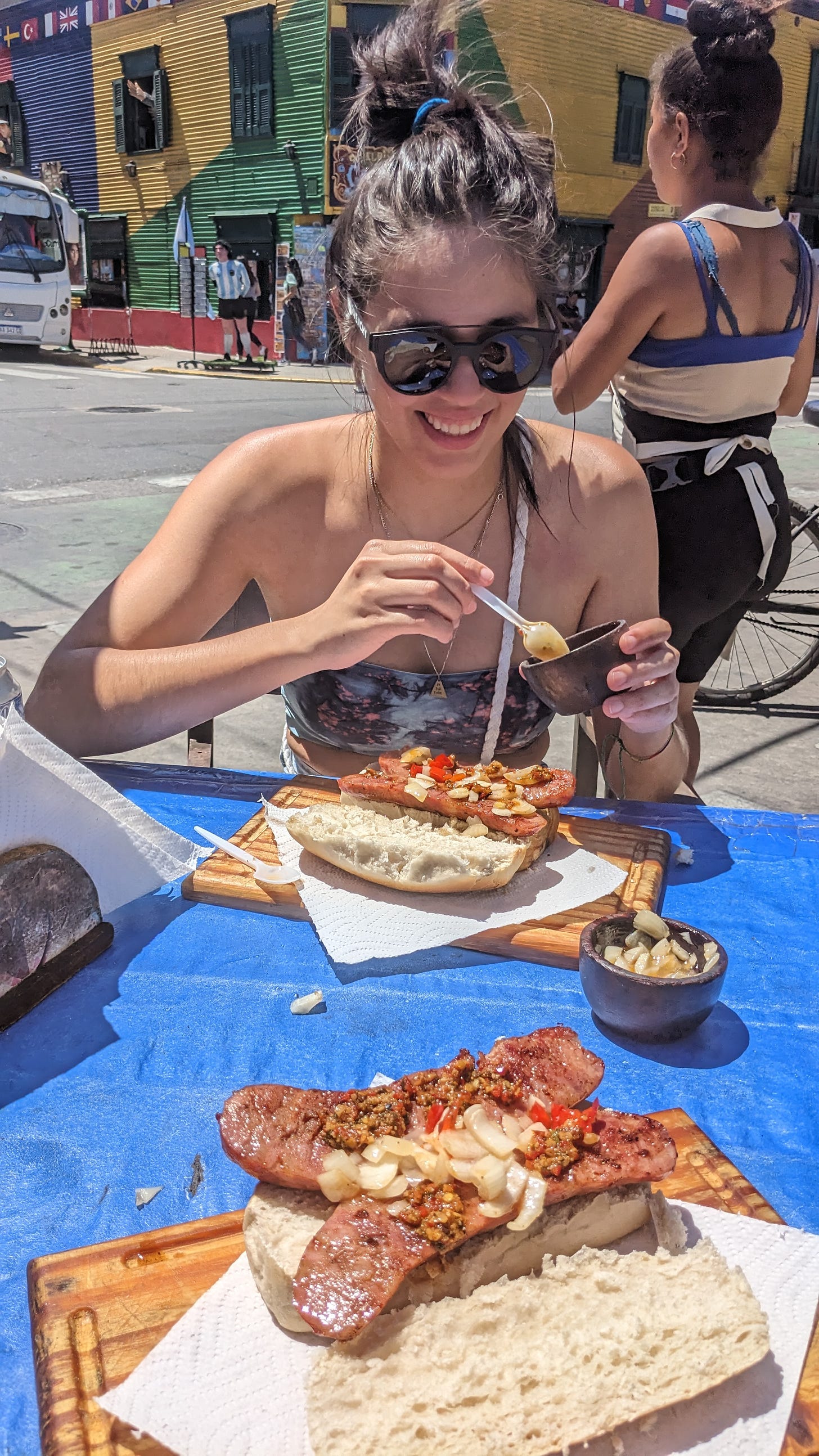 woman eating choripan in the street of Caminito Buenos Aires 